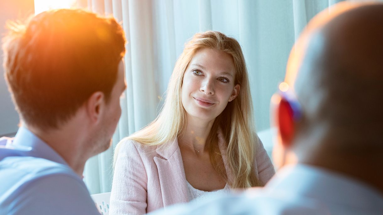Foto von Elsa Lischka im Gespräch mit 2 Kollegen