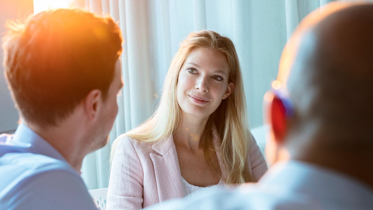 Foto von Elsa Lischka im Gespräch mit 2 Kollegen