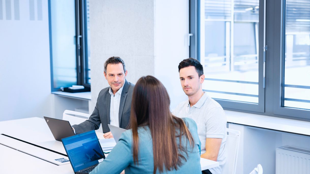 Personen sitzen zusammen an einem Tisch