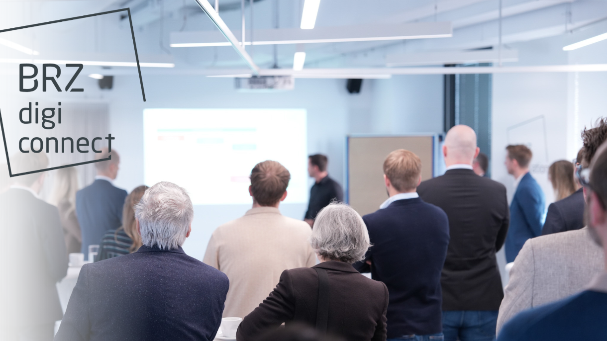 Gruppe an Menschen in einem Raum schauen auf einen Beamer