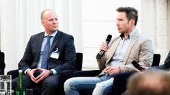 DIMCA Blockchain 7, @BRZ/Alexander Aigner 2 Männer am Podium, einer mit Mikrofon in der Hand