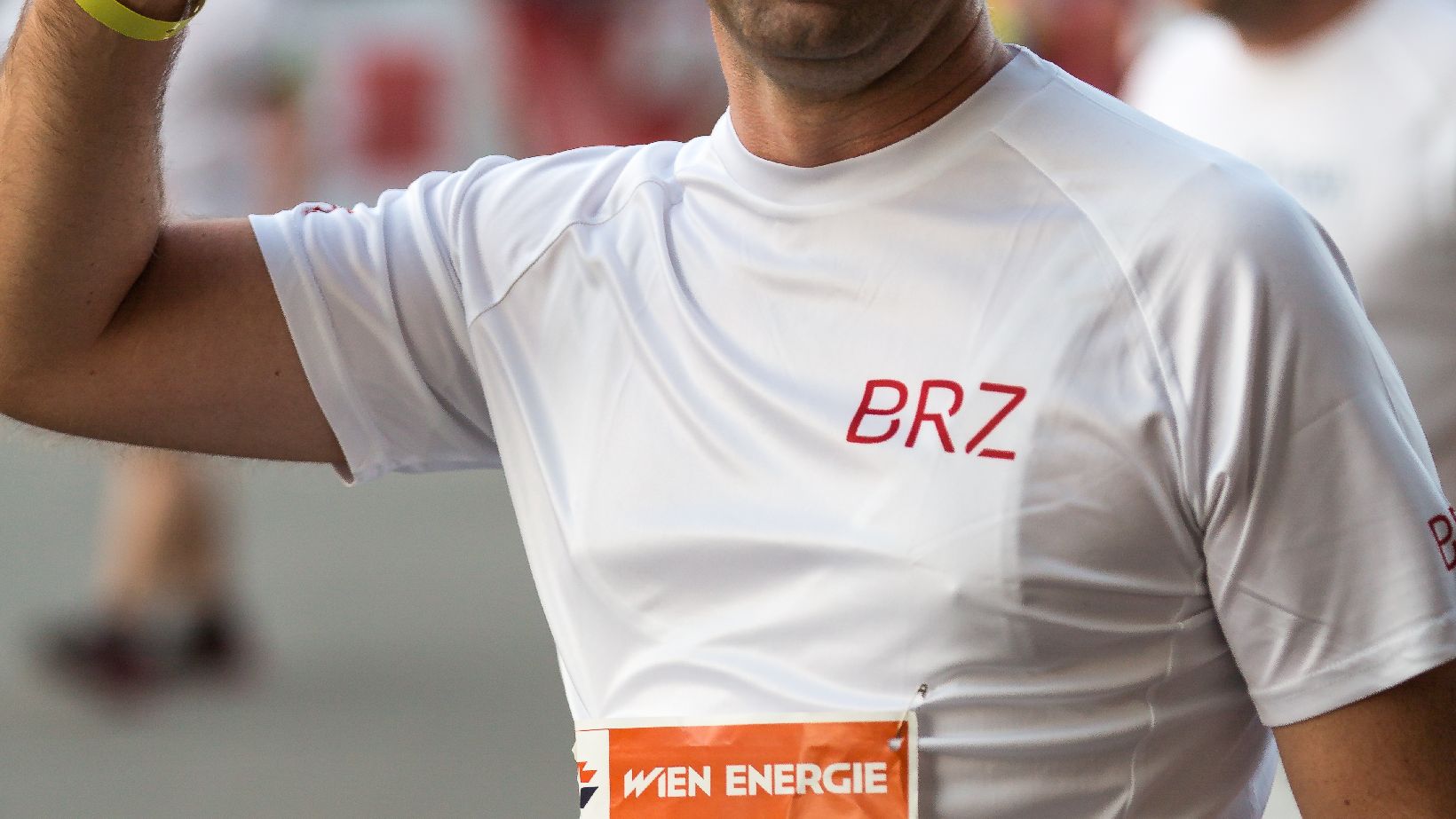 BRZ-Läufer in weißem Laufshirt, macht Victory-zeichen mit der rechten Hand