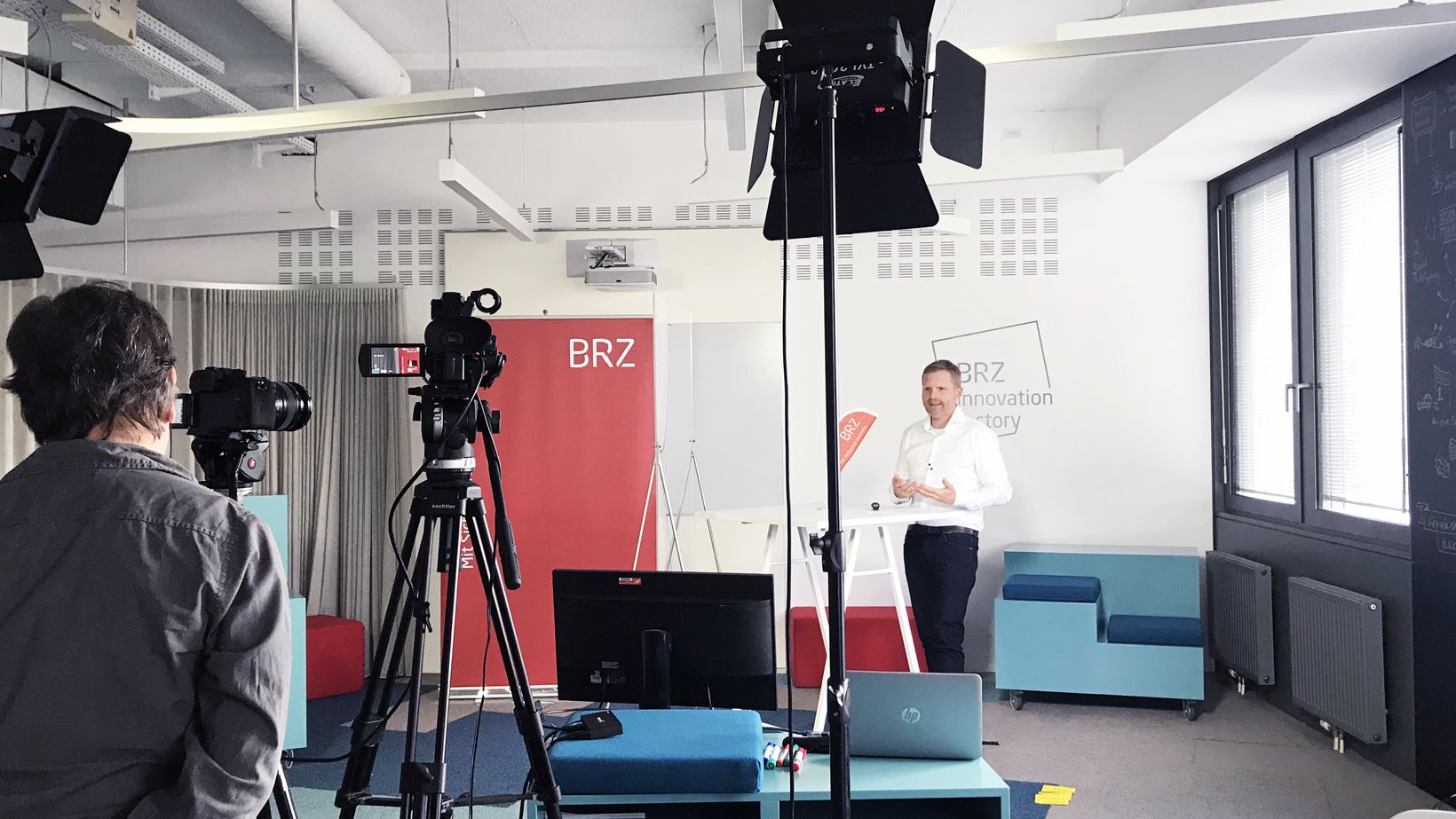 BRZ Perspektiven 1, @BRZ/Daniela Feuersinger Backstage-Bildaufnahme von Andreas Trost während der Veranstaltung. Kameramann von hinten zu sehen mit Kamera und Licht.