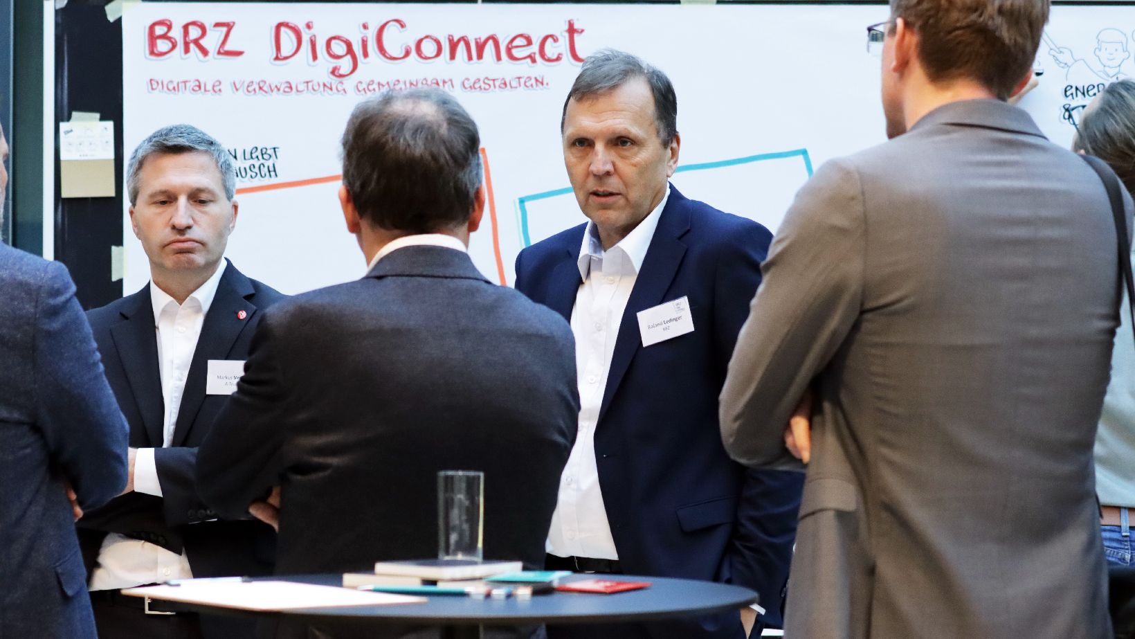 Menschen sprechen miteinander vor einer Pinwand
