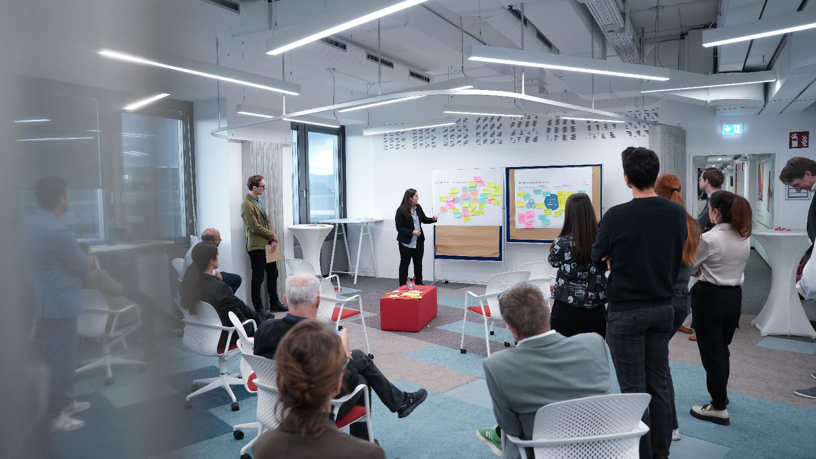 Eine Gruppe am Menschen stehend und sitzend im Raum verteilt