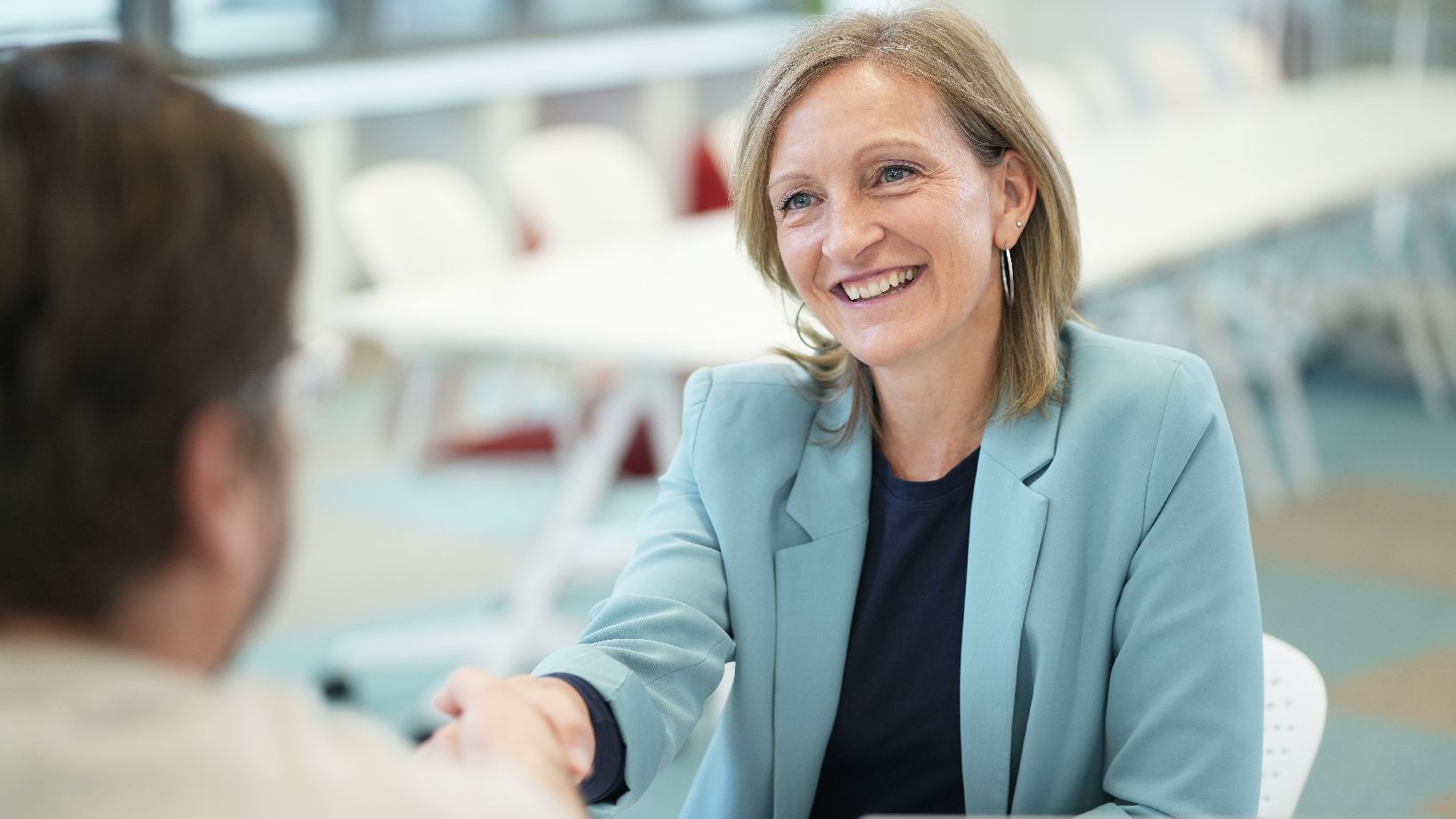 Bewerbungstipps , @BRZ/Rommelt Pineda Dame schüttelt die Hand mit einem Herrn und lächelt