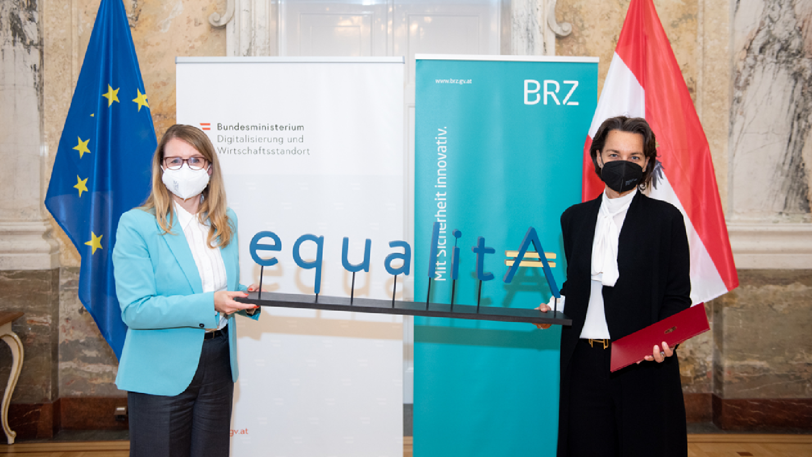 Bundesministerin Schramböck und Christine Sumper-Billinger halten die Auszeichnung