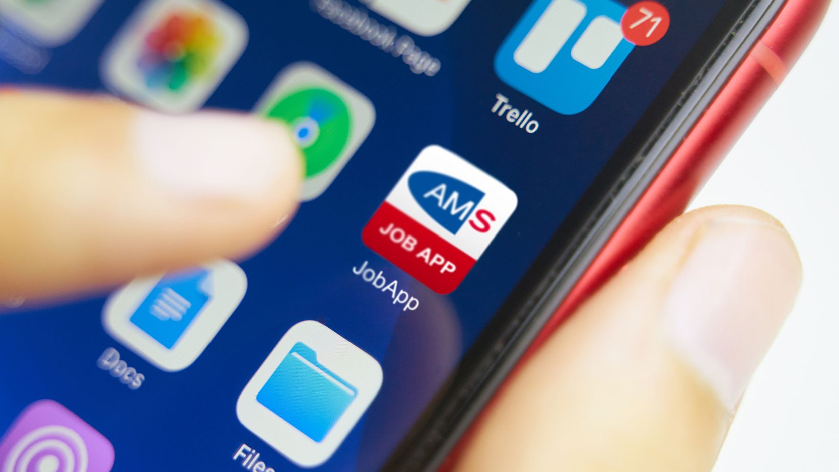 AMS JobApp, @AMS - iStock.com/Savusia Konstantin Handy mit AMS JobApp am Bildschirm