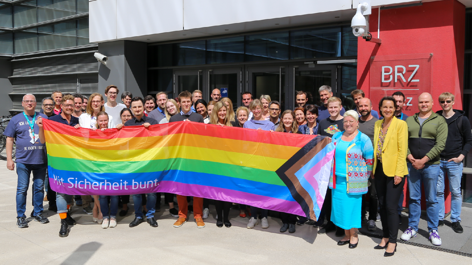 Mitarbeiter:innen mit der BRZ Pride Flagge