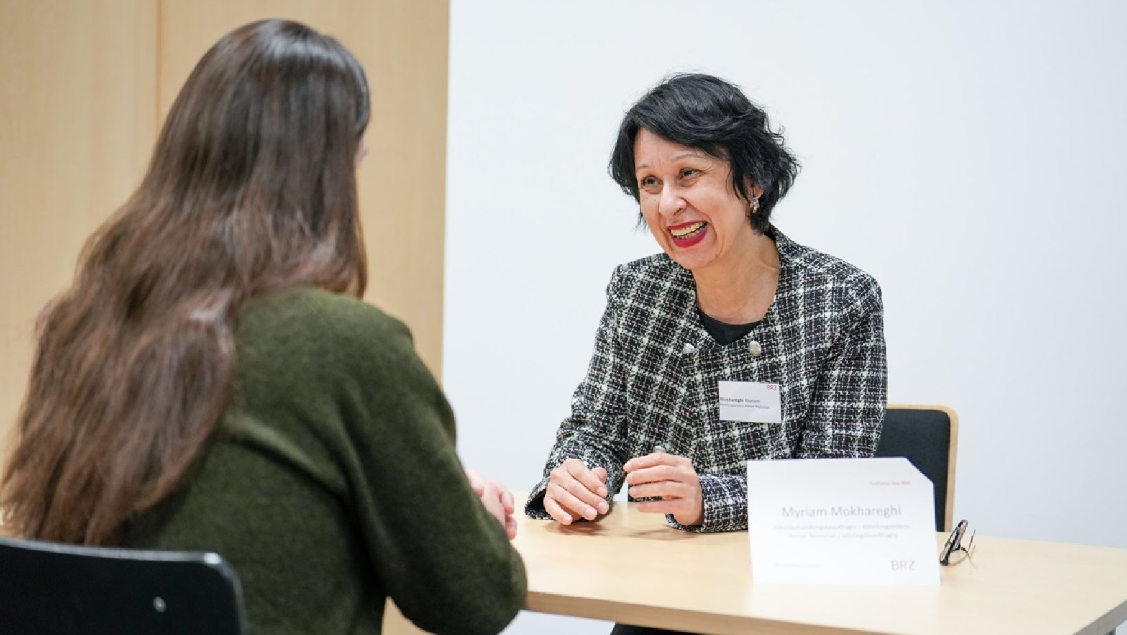 Zwei Personen sitzen an einem Tisch und sprechen miteinander